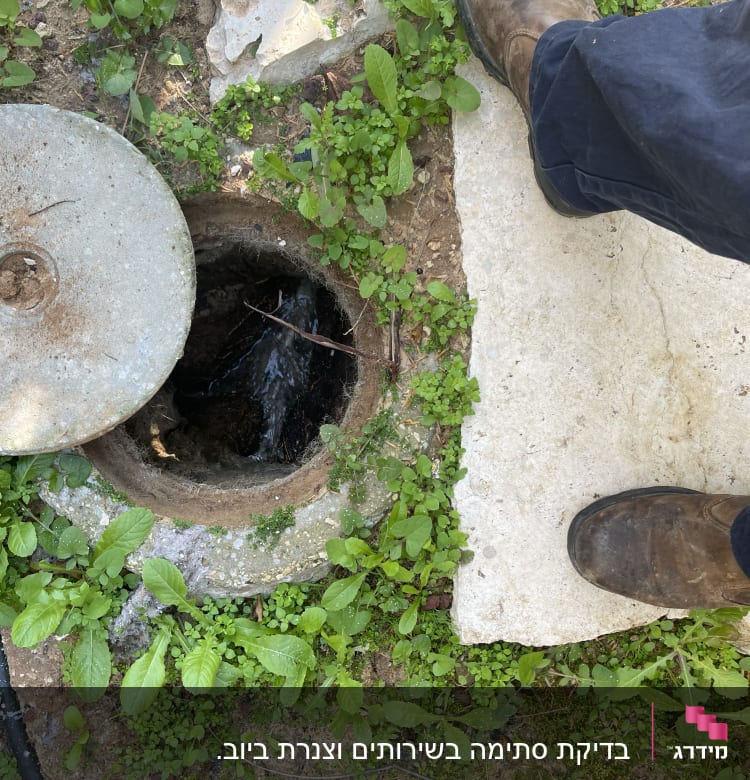 פתח ביוב פתוח עם מכסה בטון בצד